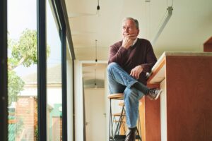 Man alone in kitchen, looking pensive